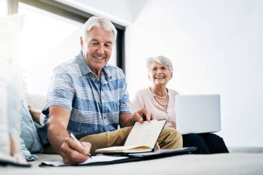 Emeklilik fonu, tasarruf ve varlık yönetimi için ev planlamasında dizüstü bilgisayar, yazı ve kıdemli çift. Çevrimiçi, bilgisayar ve faturalar, ipotek ve borç ödemeleri için bütçe notları olan yaşlı erkek ve kadın.