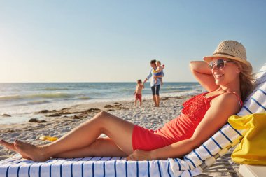 Mutlu, kadın ve plajdaki koltukta ailenle, mavi gökyüzüyle ve yaz tatilinde kaynaşma macerasıyla rahatla. Anne, güneş gözlüğü ve okyanus kenarında dinlenme, seyahat ve Yunanistan 'da tropik tatil için özgürlük.