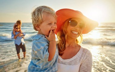 Mutlu anne, aile ve plaj gün batımında kucaklaşarak dışarıda tatil, hafta sonu ya da doğada kaynaşma. Anne, çocuk ve küçük çocuk kucaklaşmak için gülümsüyor, sevgi ya da okyanus kıyısında ya da denizde gün ışığında bakım görüyor..