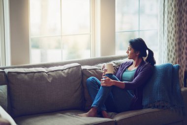 Düşünüyorum, rahatlıyorum ve Hintli bir kadın sabah kahvaltısı, latte ya da espresso için evde kahve içiyor. Çay, rüya ve rahat bir evde huzur, sükunet ve geleceği planlamak için koltukta oturan kişi..