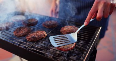 Grill, parti ve arka bahçedeki hamburgercilerle buluşmada yemek, sosyal etkinlik ya da terasta öğle yemeği. Barbekü, yemek ve erkek kişi hafta sonu evde bbq yemeği için köfte, et veya et pişiriyor.