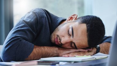 Burnout, iş ve iş hayatı son teslim tarihinden ya da iş yükünden yorulup ofiste uyuyan adam. Uyumak, dinlenmek ve yorgun düşmek. Yorgun çalışanlar, mola, iyileşme ya da dinlenme için çalışma masasında yatıyorlar..