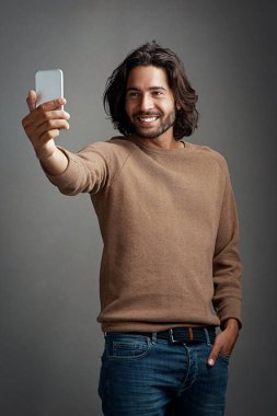 Selfie, akıllı telefon ve profil fotoğrafı için stüdyoda hafızası olan adam, sosyal medya güncellemesi ya da karanlık arka planda gülümseme. Fotoğraf, mobil ve erkek kişi mutluluk, blog yazısı veya iletişim için.