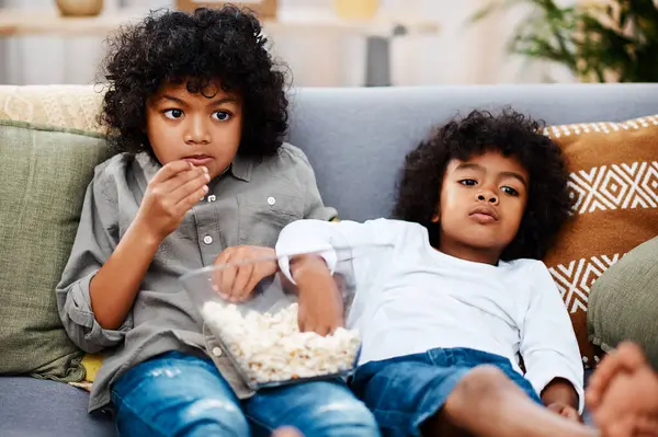 Rahatlayın çocuklar. Oturma odasında kanepede patlamış mısır yemek tatilde eğlence olsun diye çizgi film izlemek. Çocuklar, aile ve abur cuburlar çocukluk filmleriyle video aboneliği için bir arada..