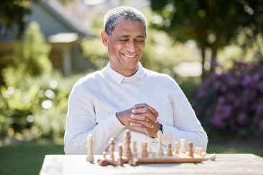 Kıdemli adam, satranç ve açık havada oynamak, hobi olarak emeklilik için planlama ve oyun mücadelesi. Erkek, mutlu ve bahçeli arka bahçede yetenek, turnuva ve yarışma için doğa.