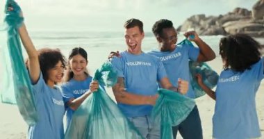 İnsanlar, çeşitlilik ve plaj geri dönüşüm çantalarıyla gezegeni kamu hizmeti veya gönüllü olarak kurtarmak için. Okyanus kıyısında Dünya Günü 'nde gülümseyen bir grup mutlu gönüllü..