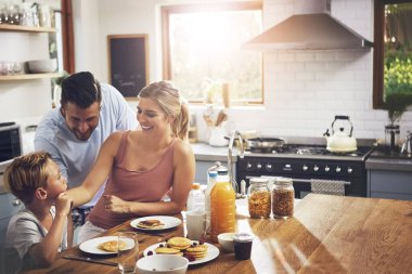 Kahvaltı, mutlu aile ve mutfakta sevgi, destek ve sağlıklı yemek için beslenme. Aileler, çocuklar ve insanlar krep, brunch ya da sağlık için masadayken evde kaynaşıyorlar..