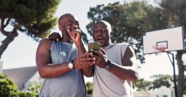 Telefon, kahkaha ve basketbol oyuncuları sahada birlikte komik, şapşal ya da komedi videoları izliyorlar. Happy, fitness ve Afrikalı erkek sporcular açık hava spor eğitiminde cep telefonlarında komik şakalar yapıyorlar.