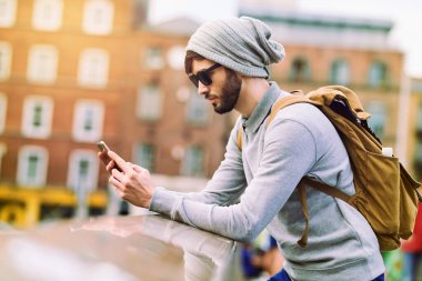 Şehir, seyahat ve balkonda araştırma, iletişim ve yer arayışı için akıllı telefonlu bir adam. İnternet, erkek ve sırt çantası Londra 'da açık hava yolculuğu, bilgi ve turizm için..