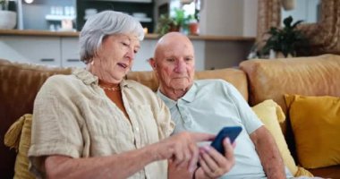 Yaşlılar, çiftler ve cep telefonları çevrimiçi ağ, sorular veya mesajlar için emeklilikte teknoloji öğrenimi için evde. Erkek, kadın ve akıllı telefon iletişim öğretmek, açıklamak ya da yardım etmek için kanepeye..