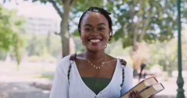 Öğrenci, doğa ve siyah kadın yüzü. Üniversitede açık hava parkında okumak için kitapları var. Mutlu, eğitimli ve kendinden emin Afrikalı genç bir kadının üniversite kampüsündeki portresi.