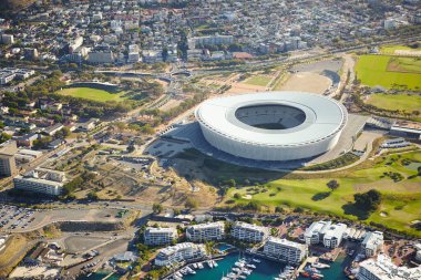 Hava manzarası, stadyum ve şehir binaları, güneş ışığı ve mimarisi olan şehir manzarası. Cape Town 'da gelişimi olan altyapı ve çevre açısından boş, spor tesisi ve doğa.