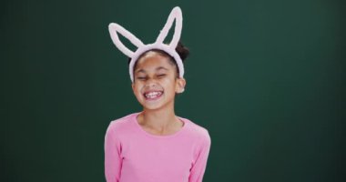 Çocuklar, yüz ya da komik kız stüdyoda eğlence, oyun ya da paskalya etkinliği ya da yeşil arka planda yarışma için tavşan kulaklı. Mutlu, portre ya da doğum günü partisi teması için tavşan kostümü giymiş heyecanlı çocuk modeli.