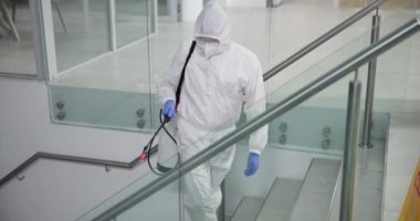 Tehlikeli madde giysisi ve merdivenleri temizlemek için kimyasallar salgın hastalık ve bakteriler için dezenfeksiyon. Erkek kişi, hapsetme ve hastalık spreyi ofise yayıldı, temizlik ve virüs güvenliği için biyolojik tehlike.