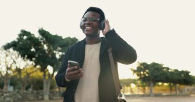 Siyahi bir adam, açık havada ve kulaklıkla müzik listesi için Atlanta 'da eğlence için gülümseyerek dans ediyor. Şarkı, albüm ve video ile canlı yayın platformu için Happy, banliyö ve internet.