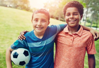 Futbol, çocuk portresi ve kucaklaşması, oyun ve açık hava tatilinde eğlenmek için parkta. Spor, çocuklar ve çimenlerin üzerinde mutlu arkadaşlar gülümseyerek, top oynayarak ve futbol için yaz kampında kucaklaşarak.