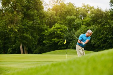 Yaşlı adam, golf ve emekli sporu, hafta sonu tatili ve çim tarlasıyla oynamak, aktif ve hobi. Aktif, emekli ve oyun, eğitim ve hareketli becerileri olan olgun biri..