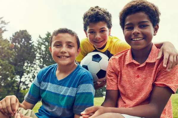 Futbol topu, arkadaşlar ve parkta oynayan, eğlenen ve dışarıda spor yapan çocukların portresi. Çocukluk, gençlik ve mutlu çocuklar futbol oynamak için tatilde, tatilde ve haftasonu doğada.