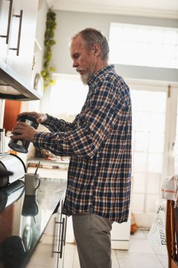 Günaydın, kıdemli adam ve mutfakta içki, enerji ya da sağlık için kahve yapmak. Emeklilik, insan ve bir fincan çay, espresso ve latte içeceği evde dinlenmek için kavanozlu içecek..