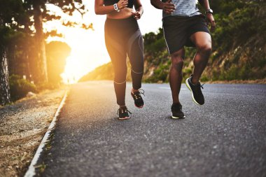 Spor, doğa ve sporcular dağda açık hava yarışı ya da maraton antrenmanı için yolda koşuyorlar. Dayanıklılık egzersizi için sokakta egzersiz yapan çiftlerin koşucusu, sağlığı ve bacakları.