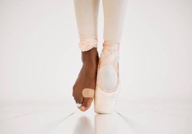 Hurt, foot and ballerina in class, dancing and balance of person on stage, plaster and injury in lesson. Studio, dancer and barefoot with bandage, pain and commitment to talent and training on floor. clipart