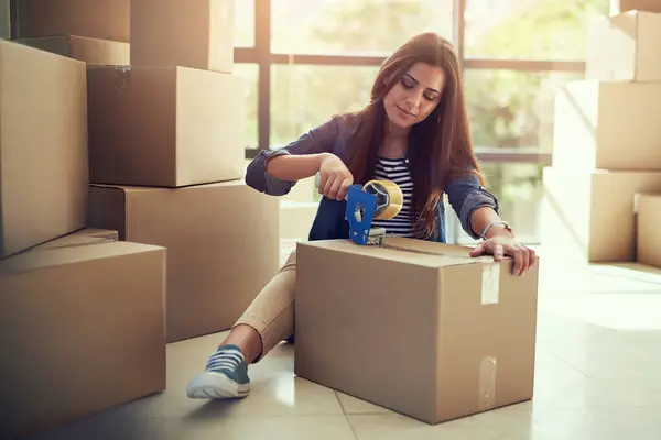 stock image Box, moving and woman on house floor for relocation, packing and real estate, sale or deal opportunity. New home, package and girl person in living room with donation, charity or ngo collection.