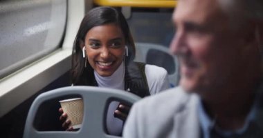 Kulaklıklar, otobüsteki kadın ve erkek, işe gitmek için telefon ve kahkaha, toplu taşıma ve şehir. Araç, yolculuk ve New York 'ta kulaklık, podcast ve canlı yayın yapan kadın çalışanlar.