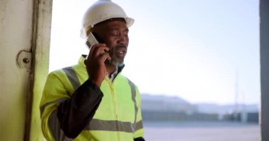 Siyahi adam, mimar ve görüşme için telefon görüşmesi, inşaat ya da bakım. Mimarlık için cep telefonundan konuşan Afrikalı müteahhit, müteahhit veya inşaat mühendisi.