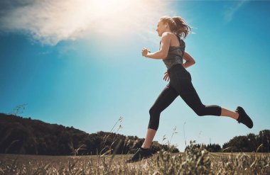 Müzik, egzersiz ve sağlıklı vücut, sağlık ve spor için parkta koşan bir kadın. Kulaklıklar, kardiyo ve iz sürme koşucuları ırk, maraton ve sporcularla açık hava eğitimi alıyorlar..