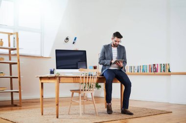 Uzaktan çalışma, insan ve teknoloji. Kitap incelemesi için yaratıcılık, iletişim ya da araştırma makaleleri için masa başında. Erkek yazar, ev ofisi veya tablet sosyal medya, internet veya geri bildirim için masada.