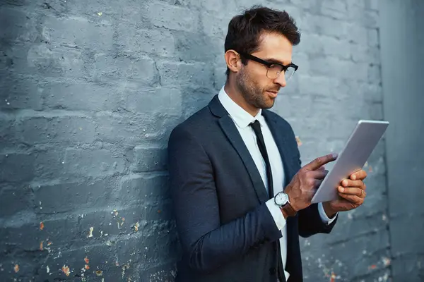 stock image Tablet, businessman and scrolling with confidence, pride and suit as accountant finance agency. Male person, financial consultant and professional in commercial industry with technology on gray wall.