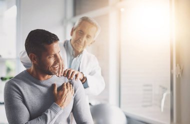 Fiziksel terapi, muayene ve iyileşme ile omuz ağrısı olan bir hasta, doktor ve erkek. Ortopedi, hekim ve silah rehabilitasyonu uzmanı danışmanlık veya tavsiye ile.