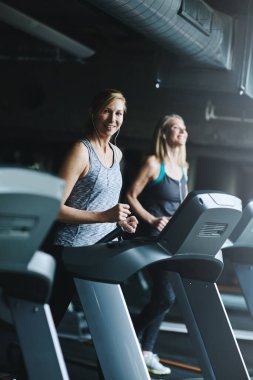 Arkadaşlar, spor salonunda spor salonu, koşu bandı birlikte koşmak ya da egzersiz yapmak için müzik. Hız yarışması için insanlar, makine ve sporcular eğitim veya egzersiz eylemi, üyelik ve ses.