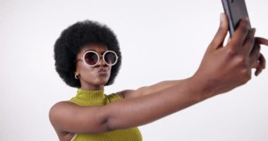 Siyah kadın, selfie ve güneş gözlükleri stüdyoda moda için izole edilmiş beyaz arka planda, eğlenceli bir şekilde. İçerik yaratıcı, gen z ve moda veya renkli tarzda mutlu, yaz kıyafetleri ve tasarımcı markası.