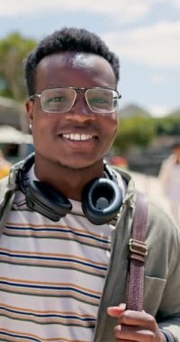Mutlu öğrenci, siyah adam ve kulaklıkla yürümek ya da eğitim için çanta, öğrenme yolculuğu ya da kampüsteki gelecek hırsı. Genç Afrikalı erkek portresi ya da üniversitede burs için gülümseme..