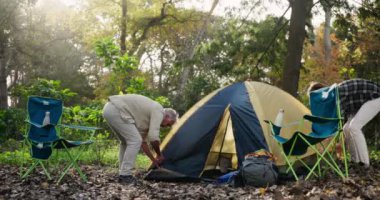 Kamp, çadırı olan baba oğul, tatil, kırsal alan ve dinlenme ile sohbet. İnsanlar, aile ve baba yetişkinler, hafta sonu tatili için yürüyüş ve orman, kaçış gezisi veya tatil.