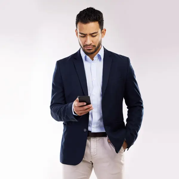 stock image Businessman, phone and online in studio, networking and browse on app or white background for work. Male person, job hunting and website for career opportunity, planning and internet for research.