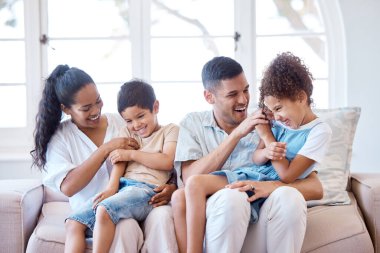 Mutlu bir aile, kanepede gülüyor ve rahatlıyor sevgi, şefkat ve çocukluk desteği ile güvenlik ve güvenlikle. Anne, baba ve eğlence, kaynaşma ve kucaklaşma için evin oturma odasında bir araya gelirler..