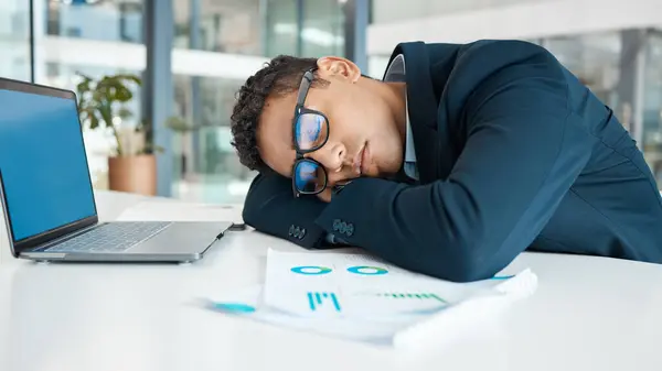 Stock image Laptop, sleeping and tired on desk, man and fatigue of overtime, nightshift and accountant. Office, exhausted and burnout of bookkeeping, overwork and person with graph in agency and rest with nap.