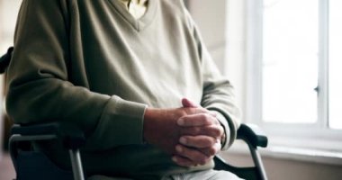 Yaşlı bir adam, tekerlekli sandalye ve bakım evindeki pencerenin yanında düşünceli, sağlığını düşünüyor ya da düşünüyor. Düşünme, hafıza ve sağlık merkezindeki engelli kişi, koridorda gençlik nostaljisi.