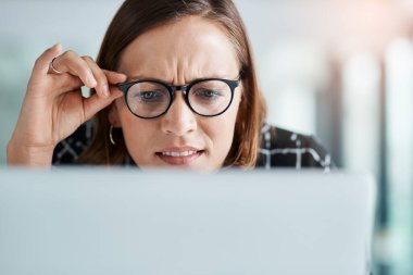 Girl, online and confused in office for reading miscommunication, unclear instructions and new software. Woman, glasses and closeup with laptop or uncertain for information overload and research clipart