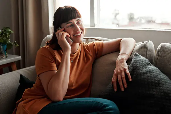 stock image Woman, phone call and hello on sofa for chat, mobile app and talking in morning or living room. Networking, technology and person in home for discussion, social media and gossip for news or story.