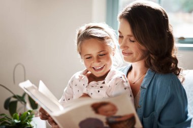 Anne, kız ve çocuk gelişimi, bağlanma ve eğitim için evde hikaye anlatmaktan mutlu. Bilgi, bilgi ve destek için kitap okumayı öğrenirken gülümseyen insanlar, ebeveynler ve çocuklar.