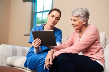 Bakıcı, kıdemli kadın ve tıbbi program, sağlık ve sağlık raporu için evdeki kanepede tablet. Danışmanlık için Halk, hemşire ve dijital hizmet, TeleHealth ve değerlendirme bilgileri.