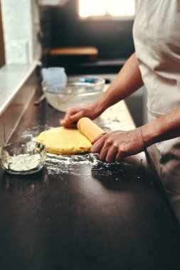 Pişirme, hamur ve ev mutfağında aşçıyla el ve tarifler için taze malzemeler pişirme. Pasta, kurabiye veya tatlı hazırlamak için önlüklü fırıncıyla yemek, pasta ve merdane..