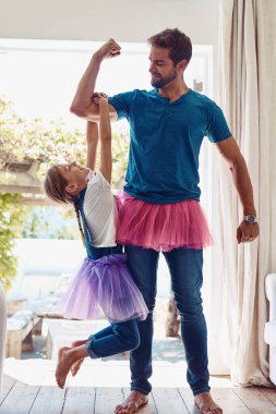 Baba, kız ve evde kostüm giyip kas esnekliği, eğlence ve güçlü kollarla oynamak. Çocuk gelişimi ve ebeveynlik için insanlar, çocuklar ve sevgi, destek ve giysi bağları.