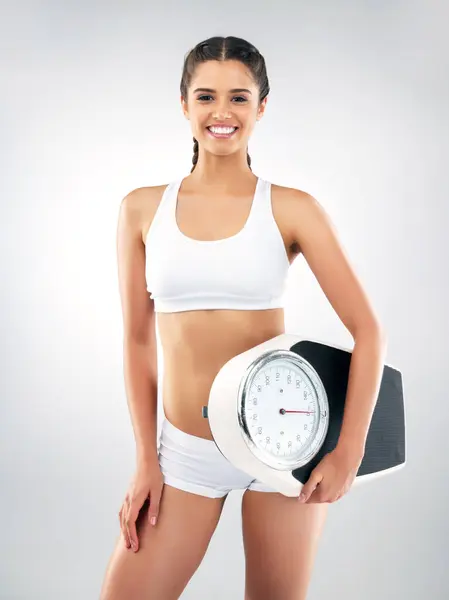 stock image Happy portrait, woman and scale in studio for lose weight, body goals and fitness transformation. Model, smile and machine to check mass with exercise results, bmi and health by white background.