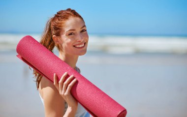 Kadın, plaj ve portredeki yoga minderiyle rahatlamak, dinlenmek ve ruh sağlığı için mutlu. İspanya 'da kadın sağlığı, refah, refah ve kendine bakımı için egzersiz ya da egzersiz yapan kadın, stres giderici ve gülümseme.