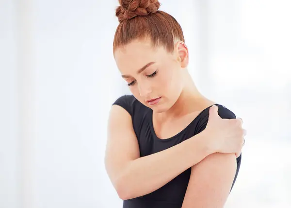 stock image Ballet, dance and woman with shoulder injury, accident or pain at rehearsal for concert at studio. Art, medical emergency and ballerina with muscle sprain, discomfort or torn ligament on arm at class.