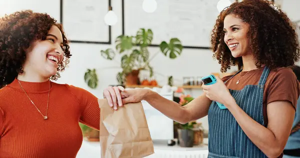 stock image Waiter, bag and customer in cafe for hospitality, payment and service with pos, fintech and transaction. Woman, technology and smile in restaurant with card machine for sale, exchange and fast food.